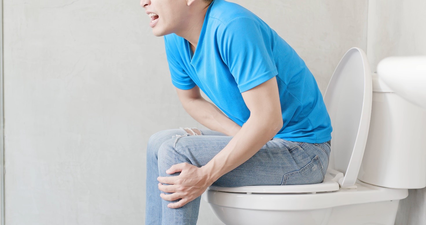 Osoba sedi na toaletu i ima bolove u stomaku
