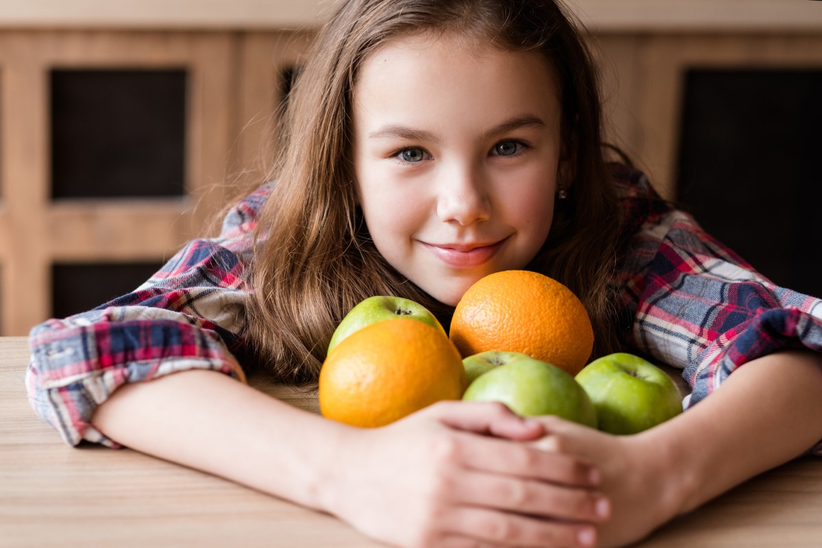 Vitamín C, v ovocí, dieťa čo drží pomaranče a jablká v náručí