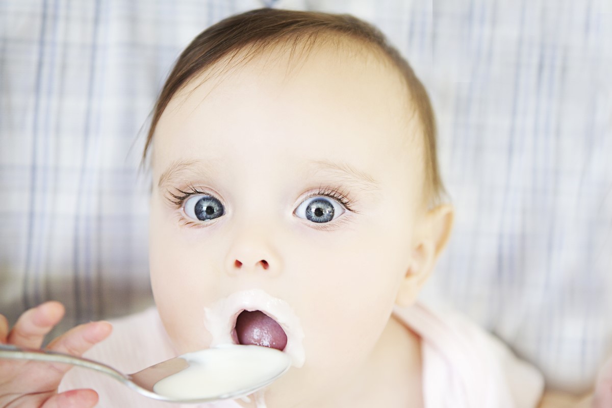 Dieťa nadobúda Dieťa s veľkými očami, konzumuje jogurt