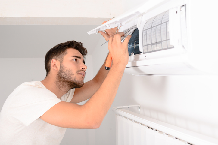 Zabezpečením riadneho technického a hygienického stavu, možno predísť výskytu, či množeniu baktérií. Foto: Thinkstock Muž ktorý opravuje klimatizáciu