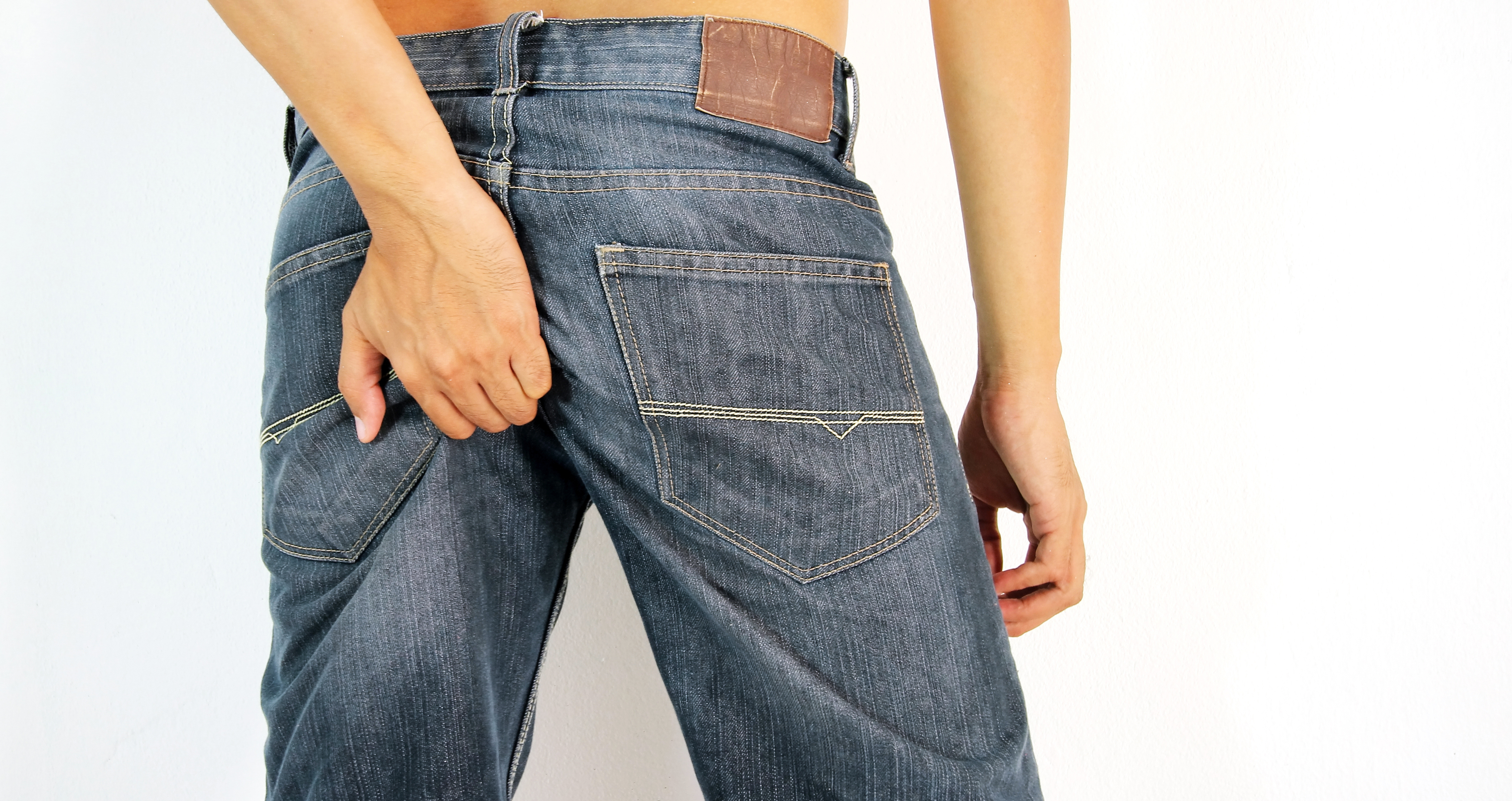 Najčastejšou cestou prenosu vírusovej enteritídy je fekálno - orálny prenos (zadok - ústa). Foto: Thinkstock muž v džínsoch si škriabe zadok