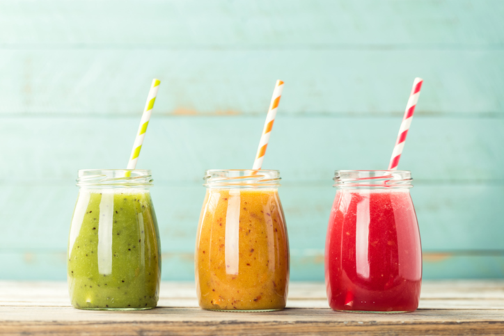 Ovocné smoothie plné vitamínov a energie Tri farebné poháre ovocného smoothie slamky - zelené, žlté a červené