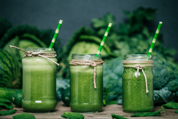 Zeleninové smoothie Zelené zeleninové smoothie, tri poháre, v pozadí kapusta, brokolica a hrach