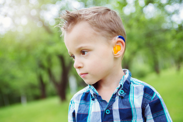 dečak sa slušnim aparatom u boji, oštećenog sluha
